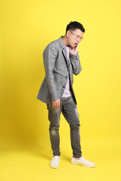 The Asian LGBTQ man with grey blazer standing on the yellow background. - Foto, immagini