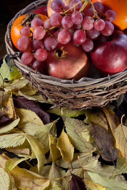 Wicker basket full of autumn fruits - Foto, Imagen
