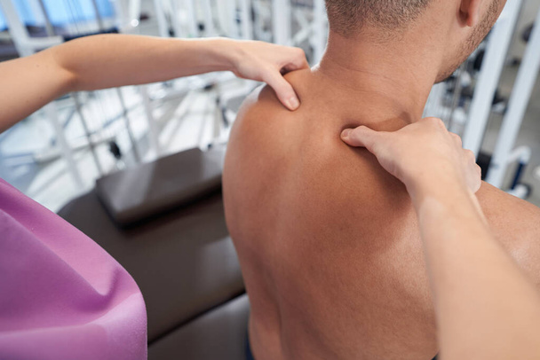 Close up of African American man receiving therapeutic shoulder massage in wellness center - Foto, Bild