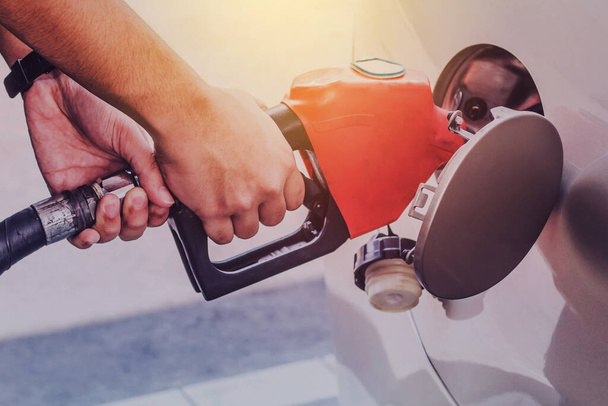 image of a man hands pumping gasoline fuel in car at gas station, self service, concept - Foto, Bild