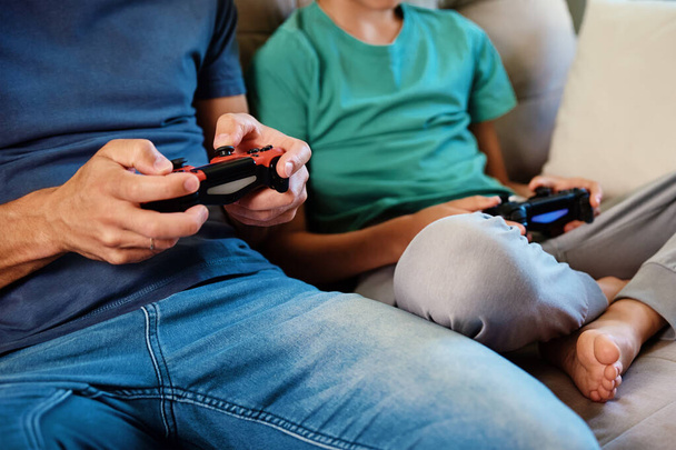 Słońce i ojciec grają w gry wideo w domu, rodzina spędzają razem czas, szczęśliwy związek, rozrywka online i rozrywka, - Zdjęcie, obraz