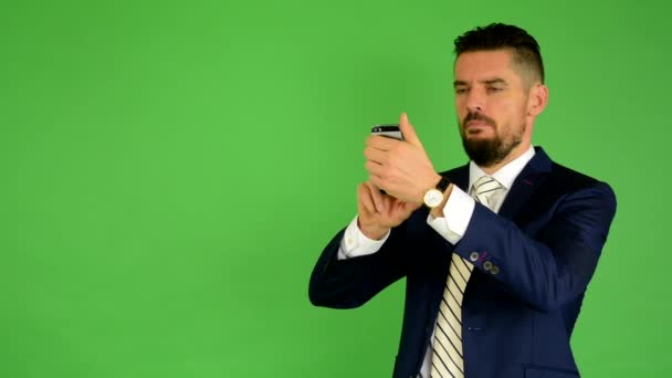 Business man photographs with phone (smartphone) - green screen - studio - Footage, Video