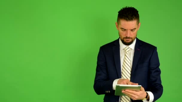 Ο άνθρωπος των επιχειρήσεων λειτουργεί σε tablet - πράσινη οθόνη - στούντιο - Πλάνα, βίντεο