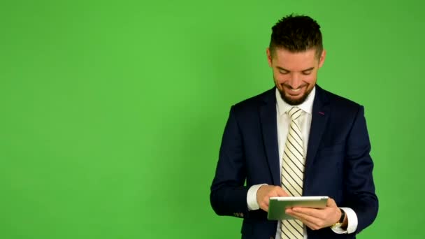 Ο άνθρωπος των επιχειρήσεων λειτουργεί σε tablet και χαμόγελα - πράσινη οθόνη - στούντιο - Πλάνα, βίντεο