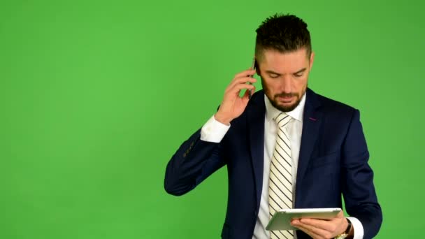 Business man on the phone and works on tablet - green screen - studio - Footage, Video