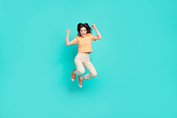 Full size portrait of astonished satisfied lady jump raise fists scream yes isolated on turquoise color background. - Фото, изображение