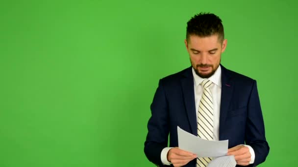 Ο άνθρωπος των επιχειρήσεων φαίνεται χαρτιά - πράσινη οθόνη - στούντιο - Πλάνα, βίντεο