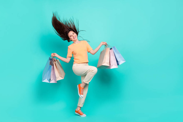 Full size photo of overjoyed nice girl arms hold packages have good mood isolated on turquoise color background. - Valokuva, kuva