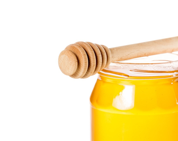 gros plan de pot de miel ouvert sur fond blanc avec trempette à miel en bois
 - Photo, image