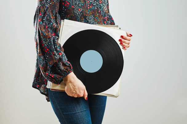 Woman holding vinyl records. Music passion. Listening to music from analog record. Playing music from analog disk on turntable player. Enjoying music from old collection. Retro and vintage. Stereo audio. Analog sound - Fotó, kép