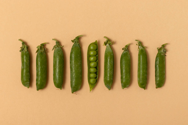 Green peas on a beige background. Top view. - Photo, Image