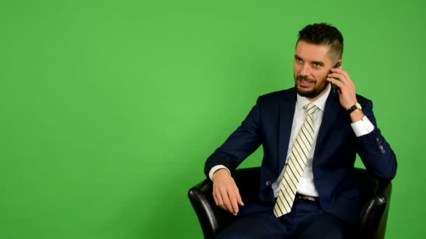 Homme d'affaires assis et téléphone et sourires - écran vert - studio
 - Séquence, vidéo