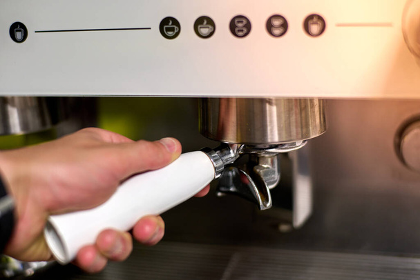 Hand squeezing to make coffee in automatic coffee maker. High quality photo - Фото, изображение
