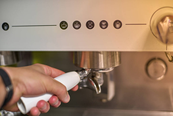 Ручное сжатие, чтобы сделать кофе в автоматической кофеварке. Высокое качество фото - Фото, изображение