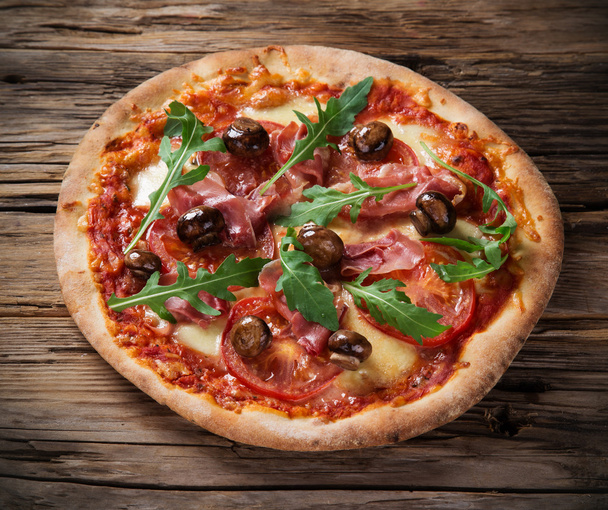 Delicious italian pizza served on wooden table - Foto, afbeelding