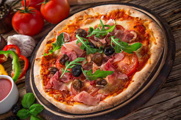 Вкусная итальянская пицца подается на деревянном столе
 - Фото, изображение