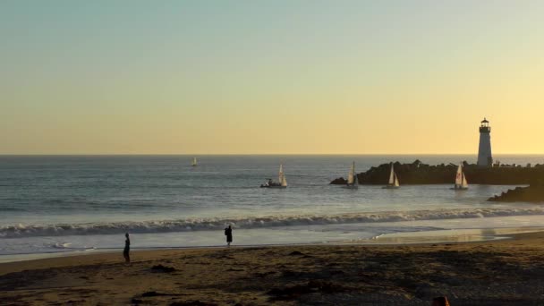 Plachetní jachty, jak je vidět z Twin Lakes Beach při západu slunce, v Santa Cruz, Kalifornie, USA, 2018 - Záběry, video