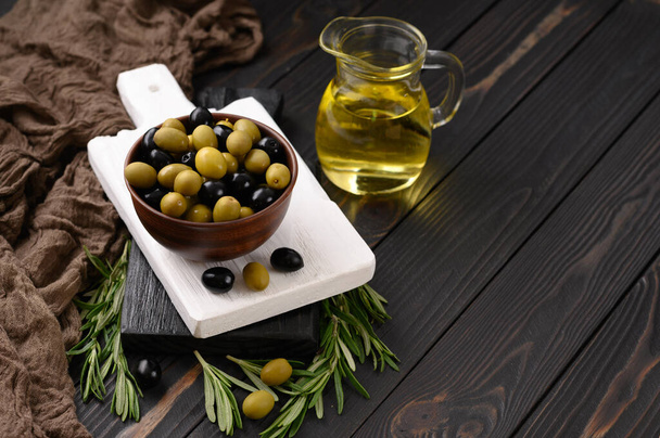 Black and green olives on a dark wooden rustic background. - Photo, Image