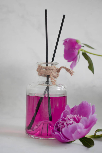 Perfume for home, peony flower on a light background - 写真・画像
