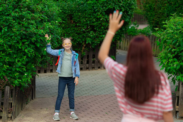 Girl with Down syndrome waving to her mother - Foto, immagini