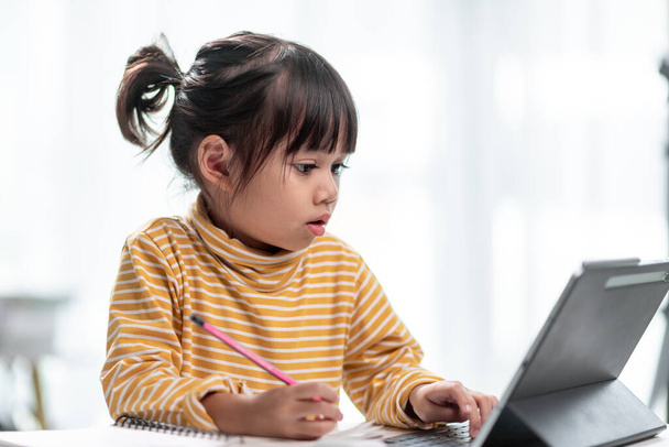 Asiática menina estudantes em aulas de aprendizagem on-line estudar on-line com Tablet em casa. - Foto, Imagem