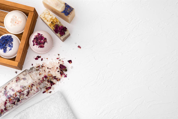 Бары из красивого натурального мыла ручной работы, соли и бомбы на белом деревянном фоне - Фото, изображение