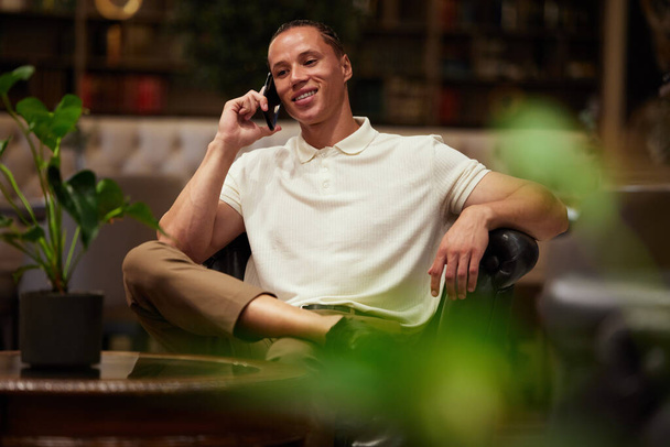 a handsome young businessman making a call while sitting in a coffee shop. - Photo, image