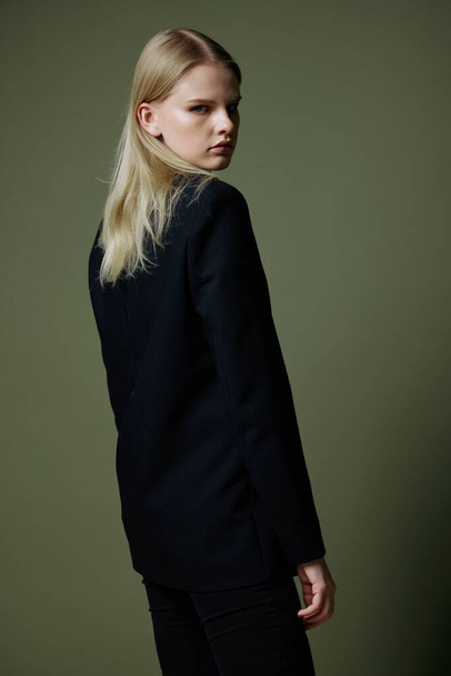 The blonde poses with her back to the camera. Concept photo for clothing brands. Cool offer for fashionable suits. High quality photo - Foto, Imagen