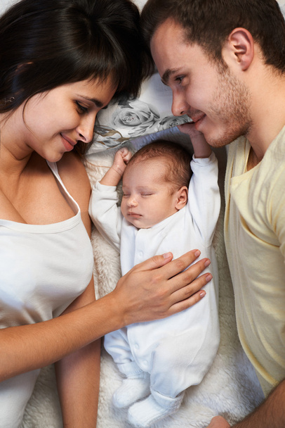 newborn lies between loving father and mother - Foto, immagini