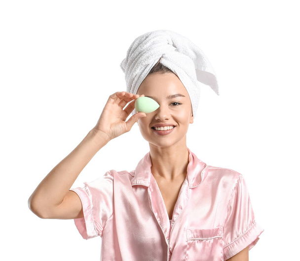 Pretty young woman with green makeup sponge on white background - Photo, Image