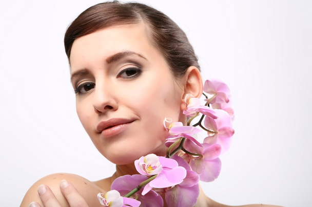 Beautiful Girl With Orchid Flowers. - Фото, изображение