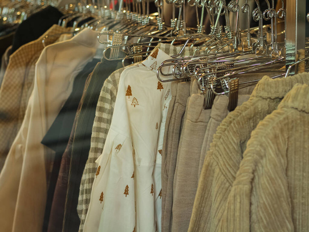 Μοντέρνα ρούχα σε ένα κατάστημα μπουτίκ. Ψώνια. Γυναικεία μοντέρνα casual ρούχα στο κατάστημα στη βιτρίνα. Κανείς, φωτογραφία δρόμου. - Φωτογραφία, εικόνα