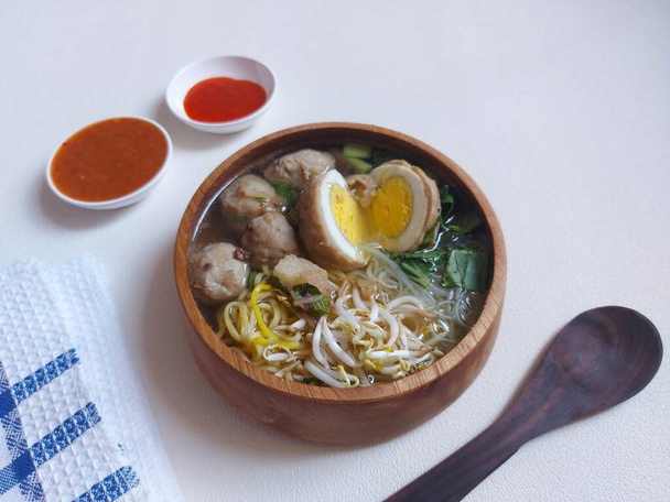 egg meatballs. completed with mustard greens, sprouts, yellow noodles, sound.  served on wooden bowls.  savory taste.  isolated background in white. - 写真・画像