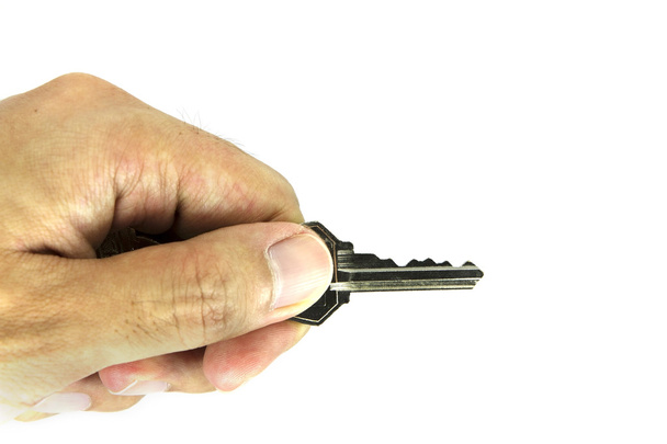 Man Hand holding silver key isolated on white background - Фото, изображение