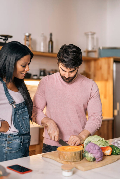 Cute multi-ethnic couple preparing lunch together in the kitchen at home. - Foto, Bild