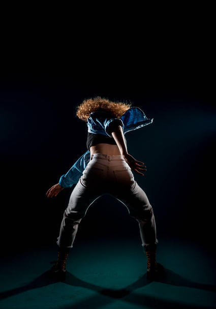 Fit young girl dancer performing a dance routine in the black studio - Foto, Imagem