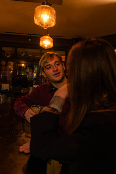 Two attractive and beautiful people are flirting with each other on the bar while talking - Photo, Image