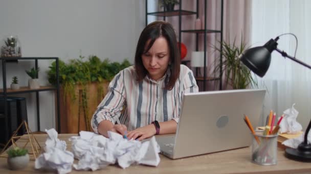 Smutná mladá žena pracující v domácí kanceláři a přemýšlející o psaní na papír. Nespokojená obchodnice zmačká odepsaný list papíru se špatnými nápady a chybami. Krize - Záběry, video