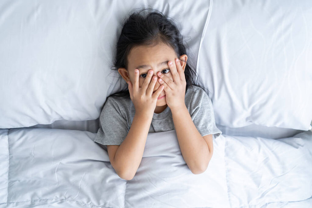 Top pohled asijské dítě holčička byla vyděšená před spaním - Fotografie, Obrázek