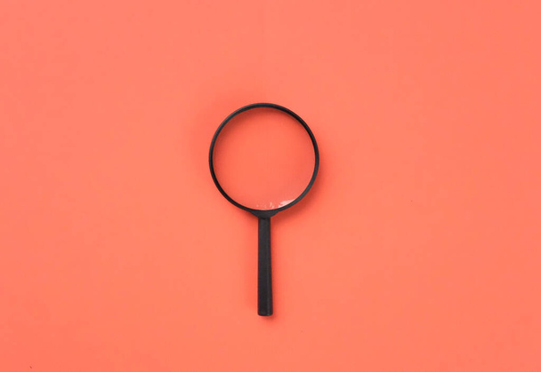 loupe or magnifying glass as internet search symbol. orange background with copy space - 写真・画像
