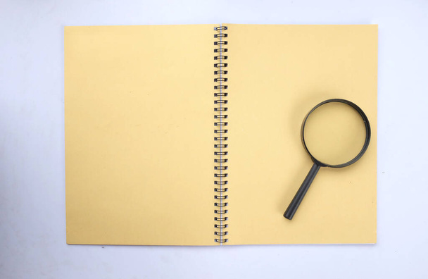 Magnifying glass  with notebook  yellow isolate on a white background. Searching concept. - Photo, Image
