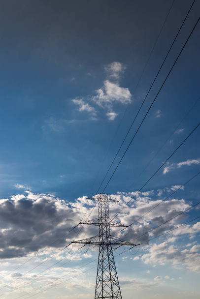 Photo of Power transmission tower with blue sky as background. Air electric lines. - Photo, Image