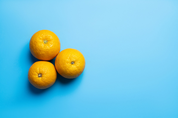 Top view of oranges on blue background with copy space - Fotó, kép