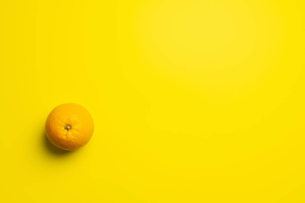 Top view of orange on yellow background  - Foto, Bild
