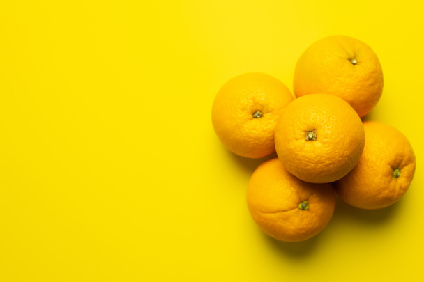 Top view of juicy oranges on yellow surface with copy space - Photo, image