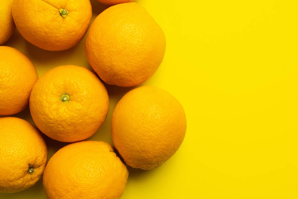 Pohled shora na celé pomeranče na žlutém pozadí  - Fotografie, Obrázek