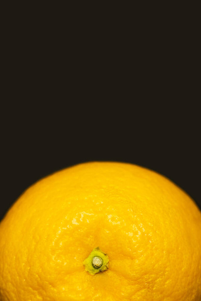 Close up view of orange in peel isolated on black  - Foto, afbeelding