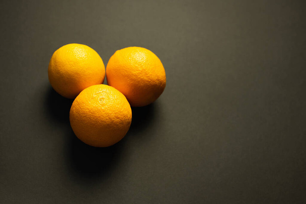 Top view of fresh oranges on black surface with copy space - Valokuva, kuva