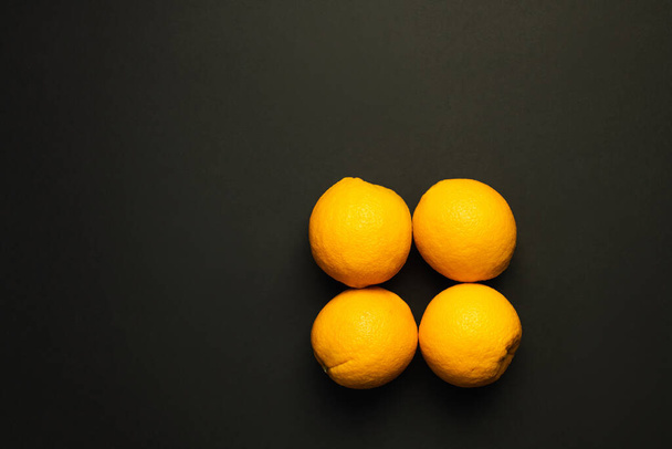 Top view of sweet oranges in peel isolated on black  - Fotoğraf, Görsel