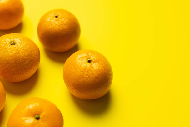 High angle view of sweet tangerines on yellow background - Фото, зображення